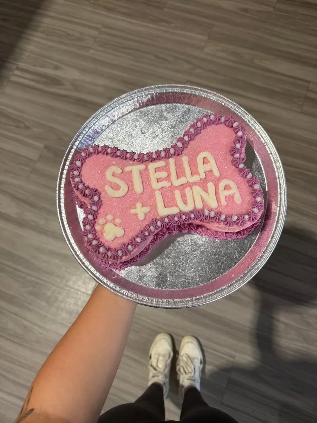 A pink bone-shaped cake made for two dogs